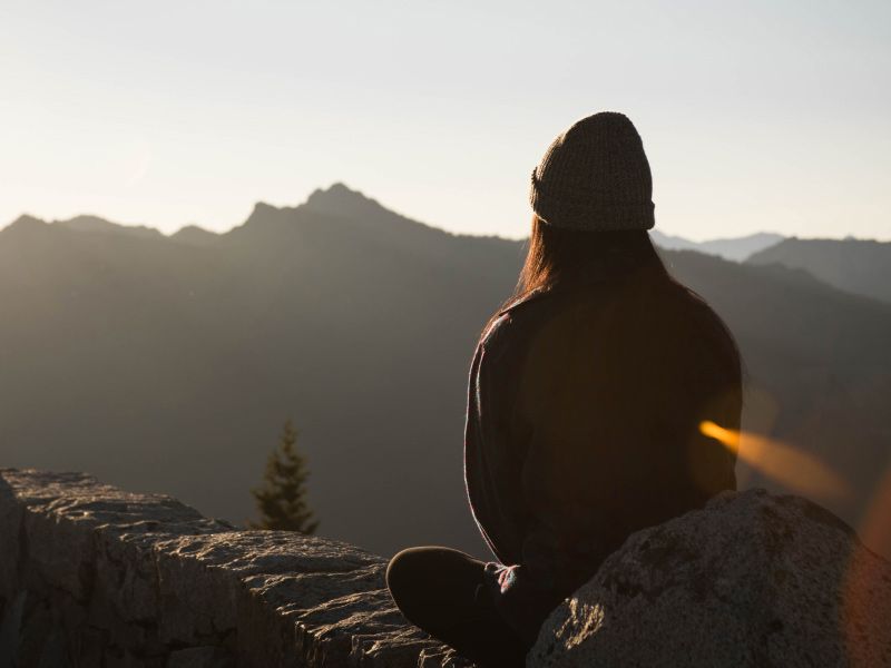 a woman meditating on a mountain