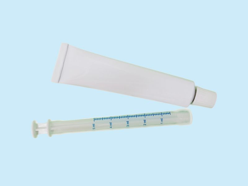 Antifungal cream tube and applicator with a light blue background