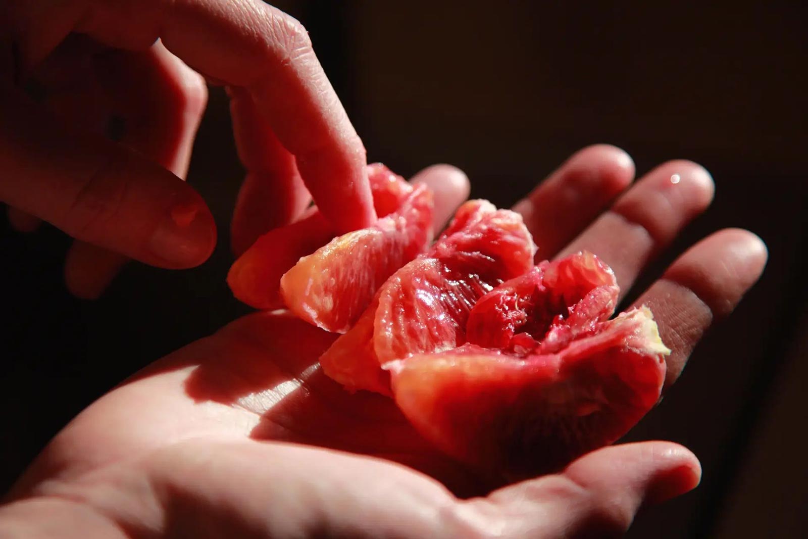 hands holding a juicy piece of fruit