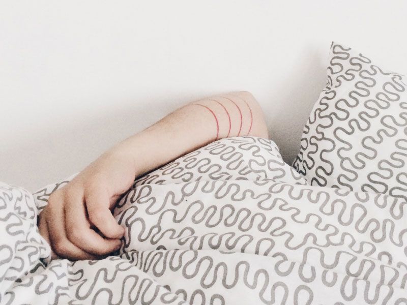 person's arm resting on bedding with a fun geometric pattern