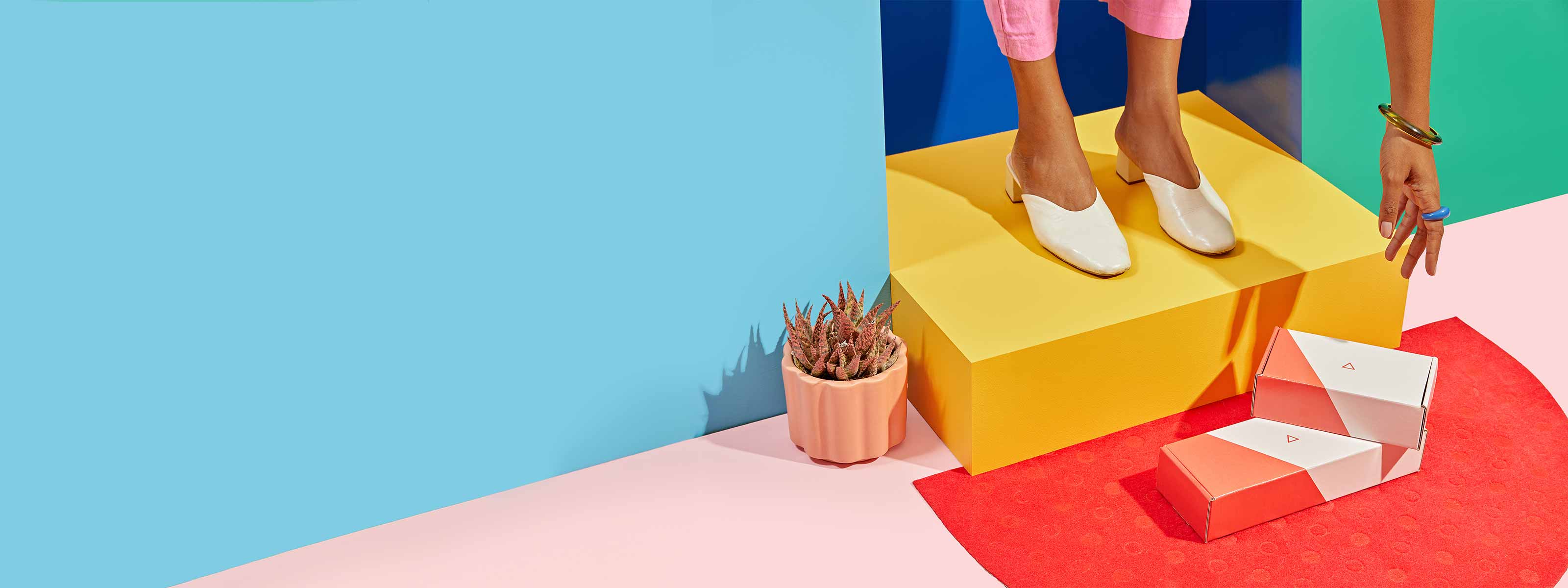 A woman reaches for Wisp delivery boxes sitting on a red doormat