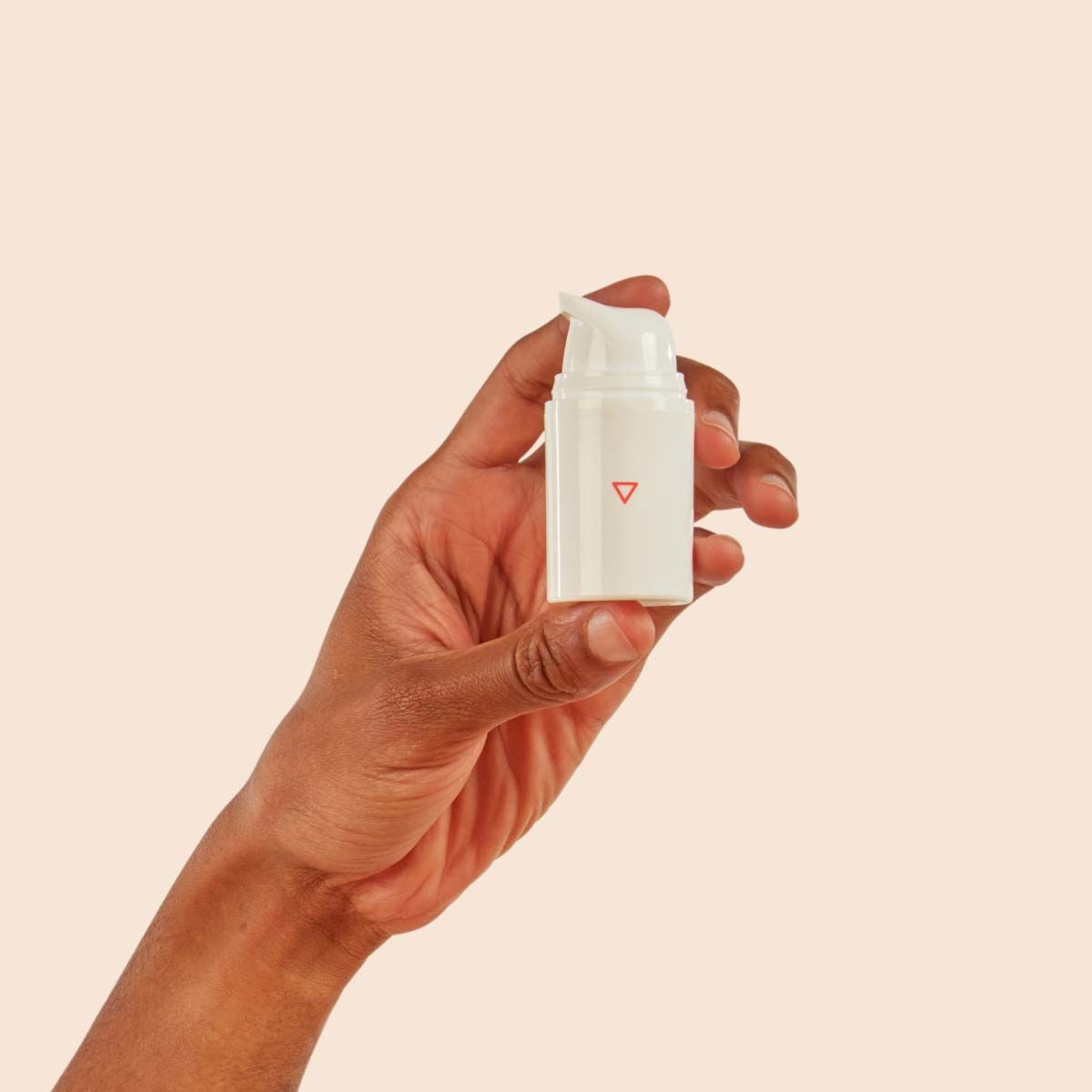 Bottle of Acyclovir cream in someone's hand with a cream backgroound