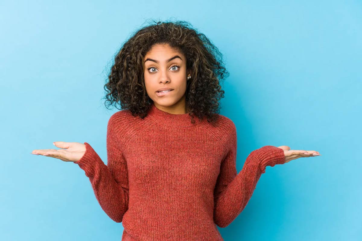 woman shrugging against a blue background