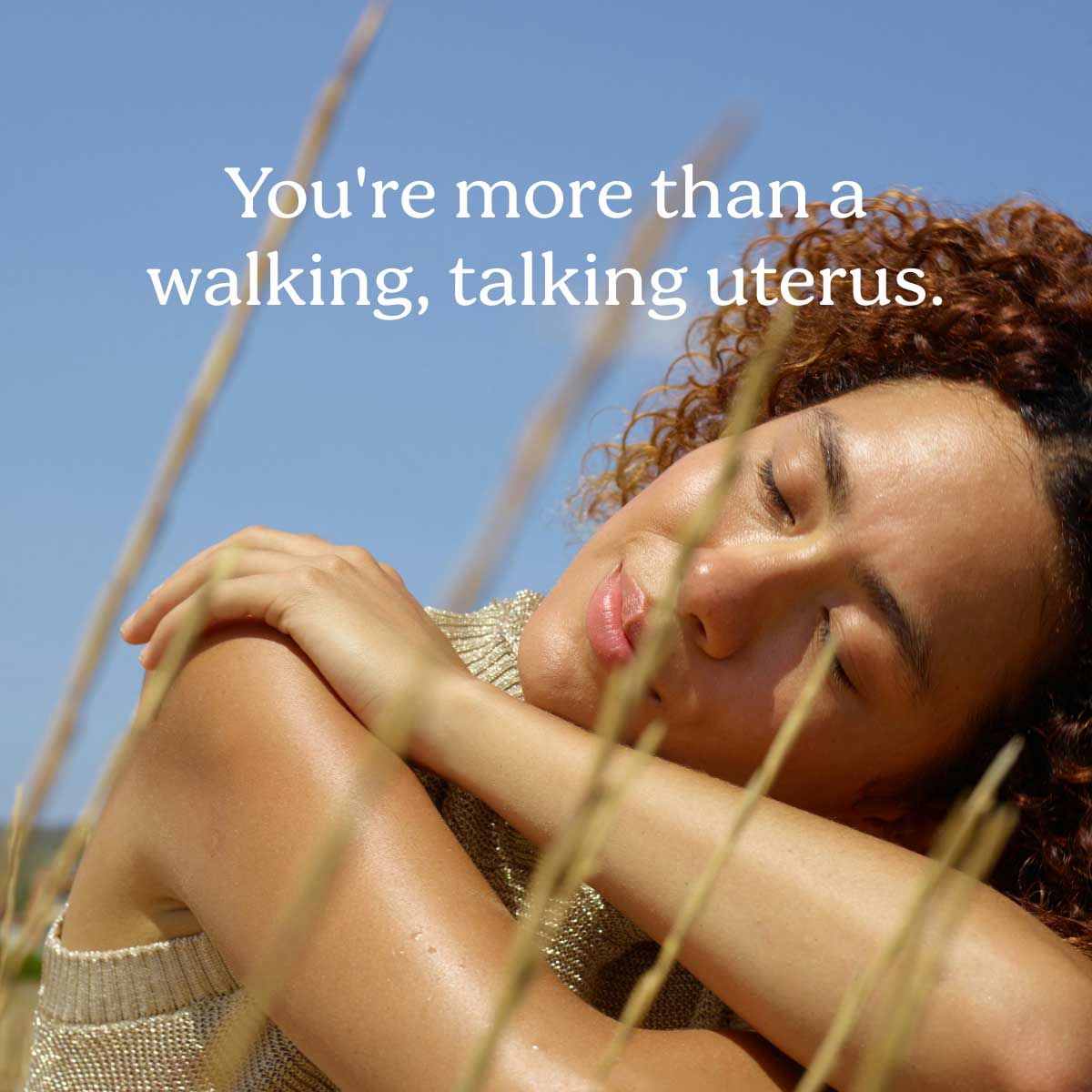 A pretty woman with curly hair looking peaceful outside with sun on her skin
