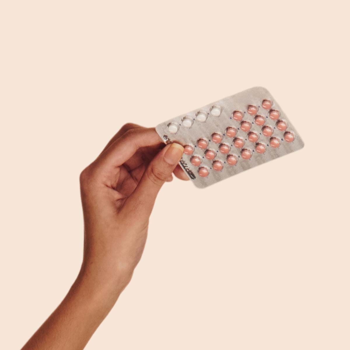 Packet of birth control pills on a cream background