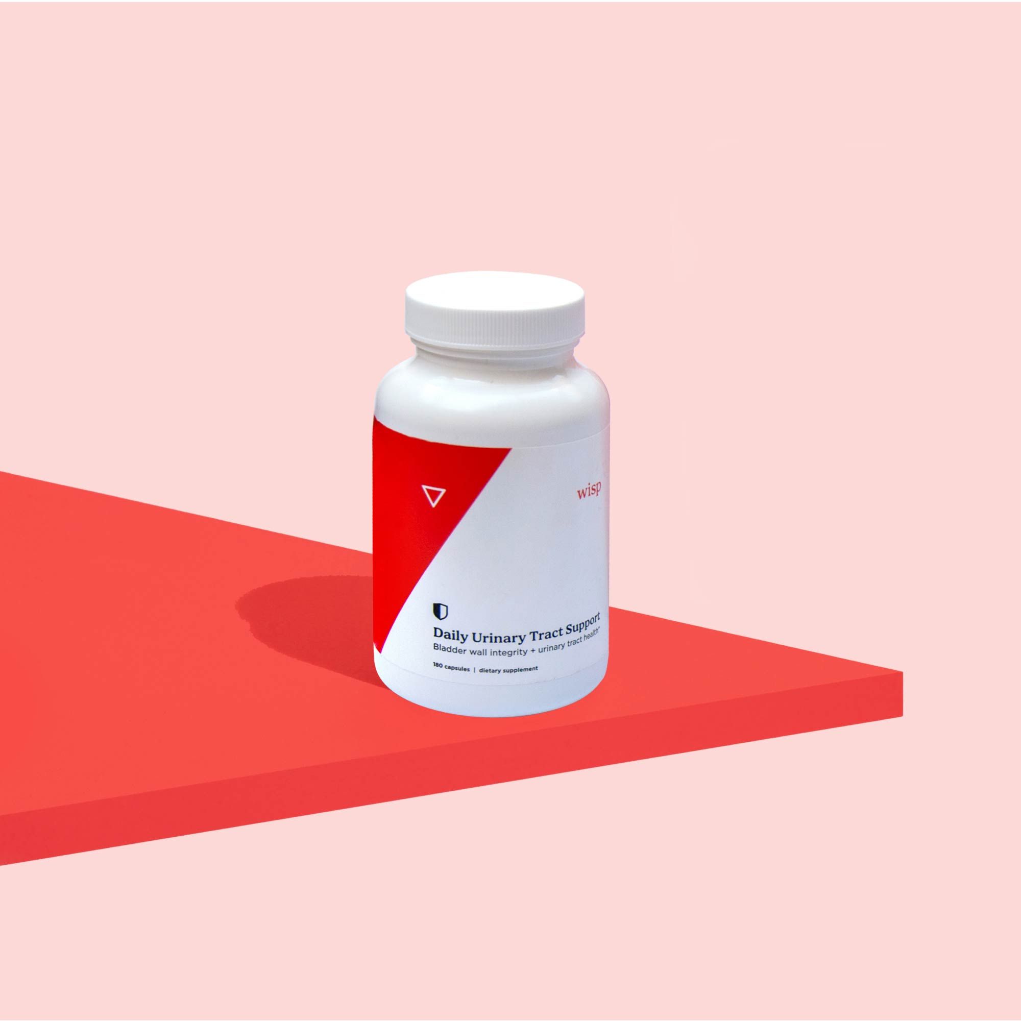 Wisp Daily Urinary Support Capsules on a red surface with a pink background
