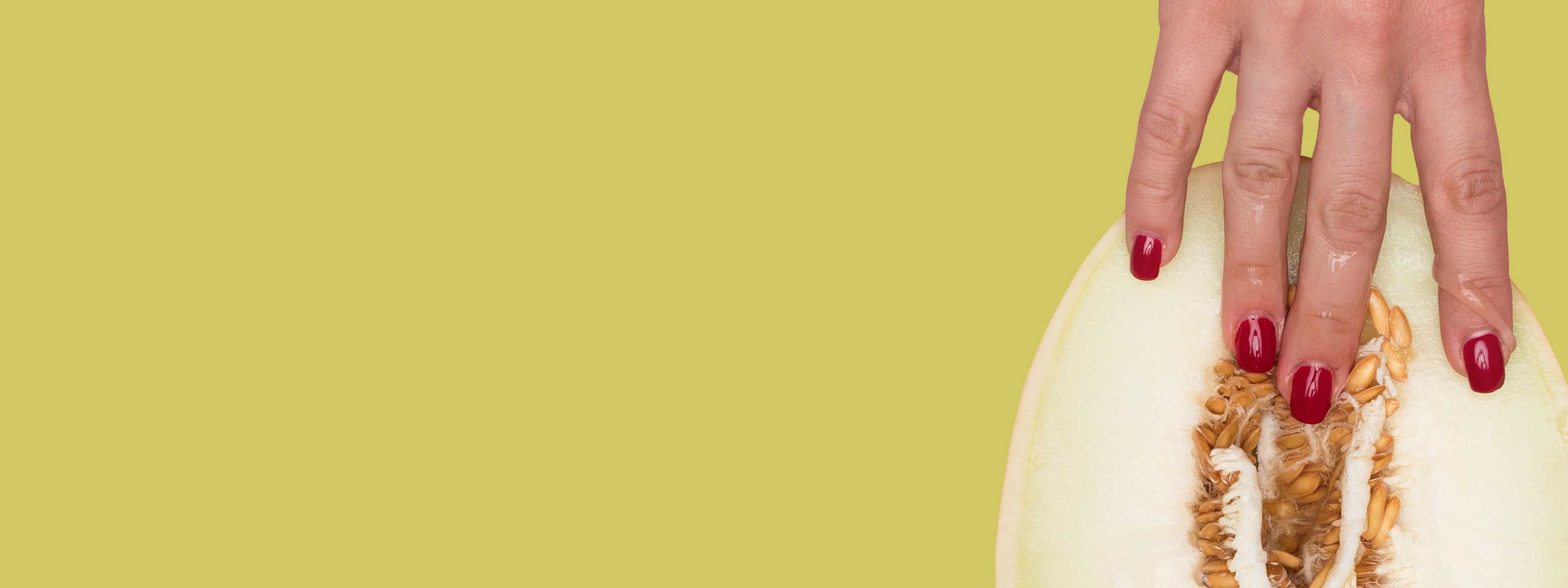 Hand touching sliced melon against green background