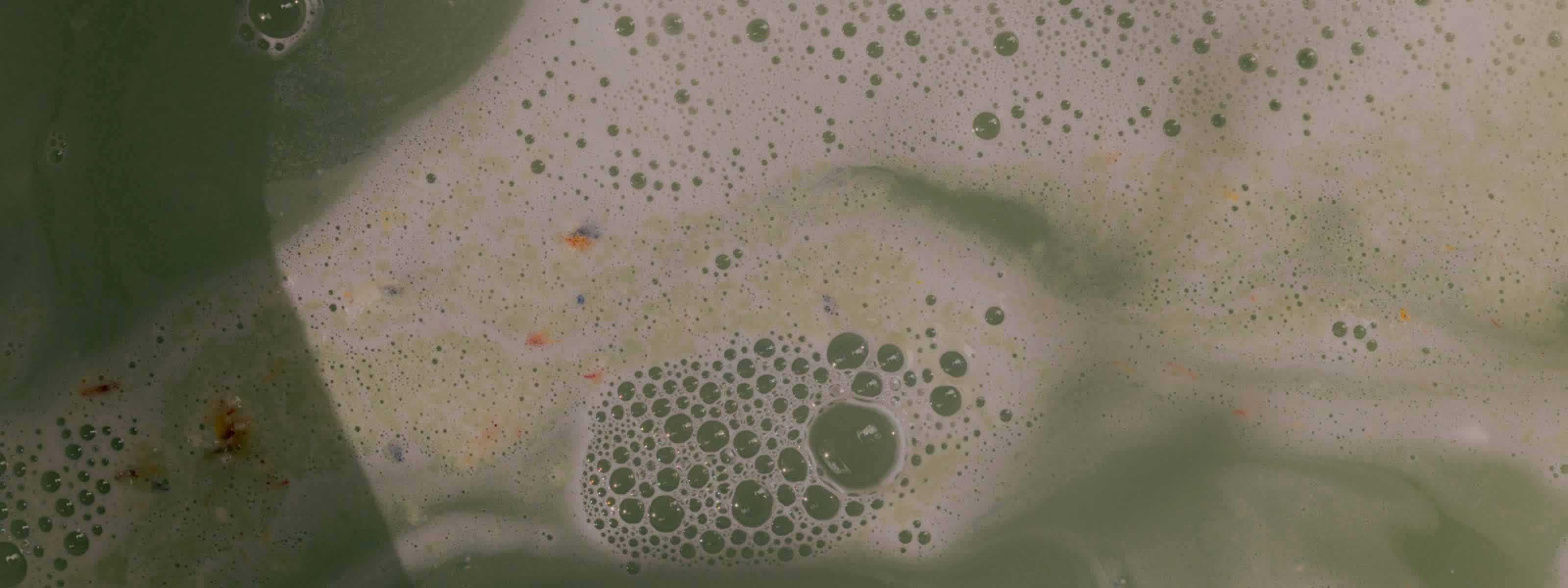 Green-tinted water with foamy suds