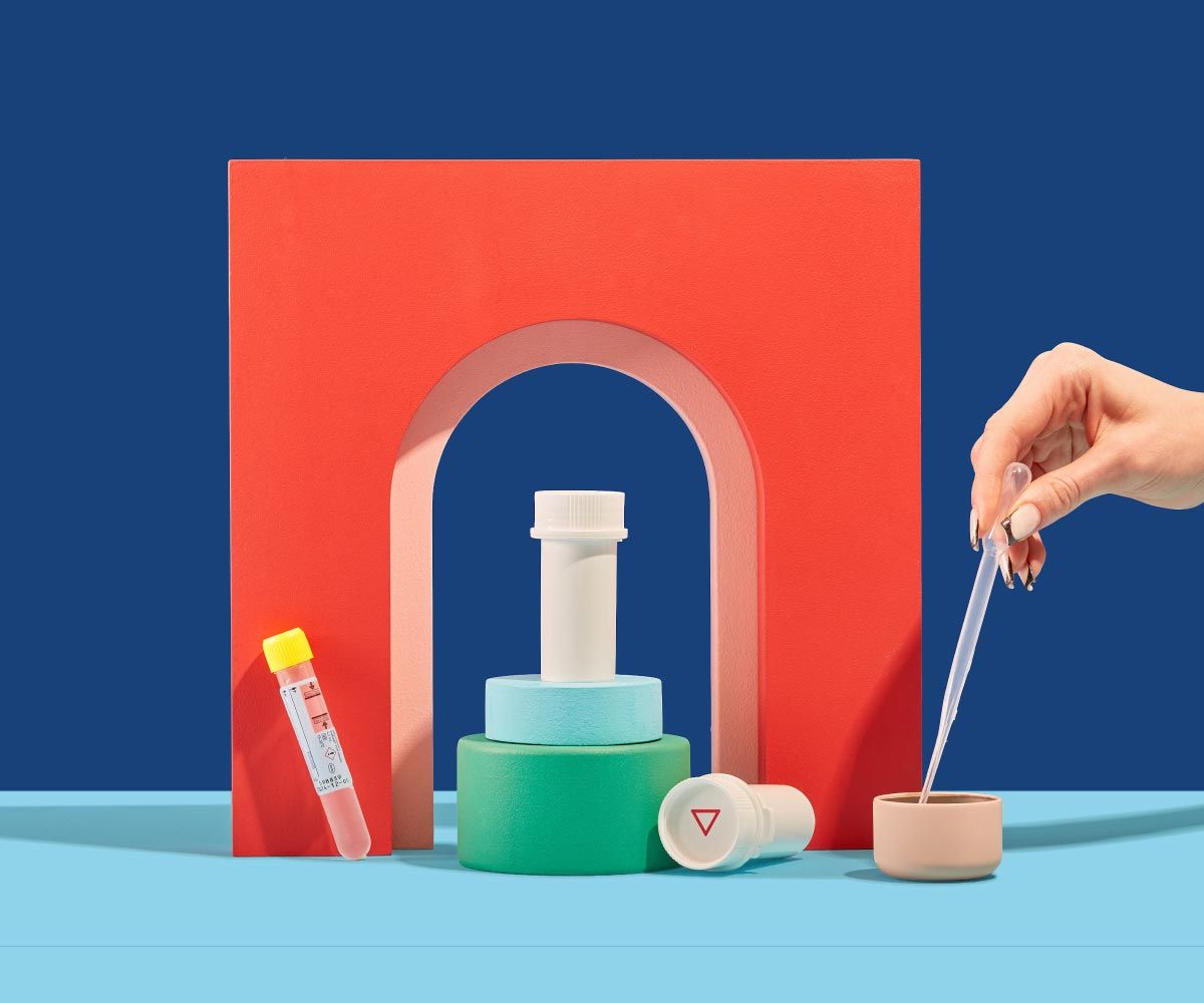 Wisp pill vials and test tubes are balanced on colorful abstract shapes on a blue surface