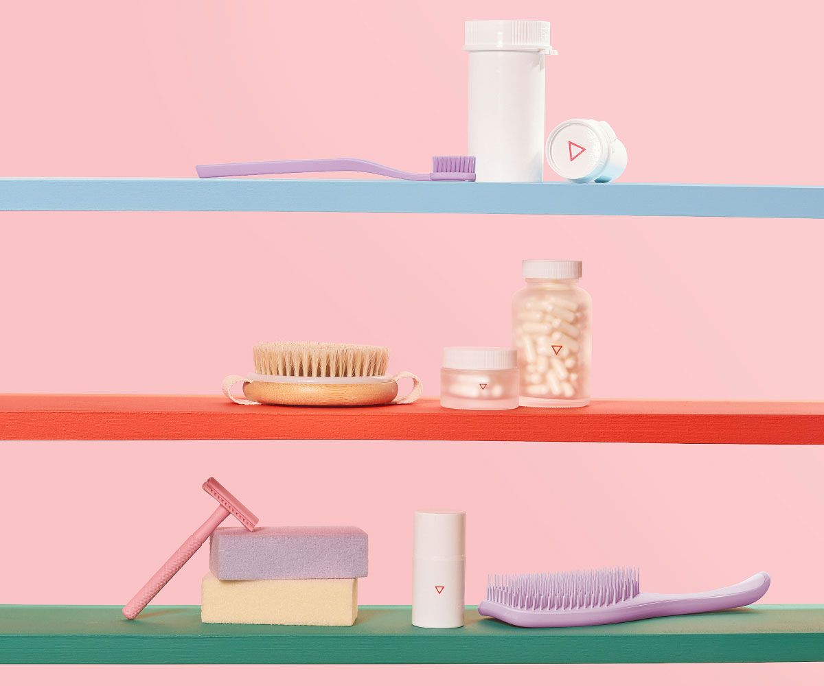 Various Wisp products, a purple toothbrush, a pink razor, colorful bars of soap on colorful shelves with a pink background
