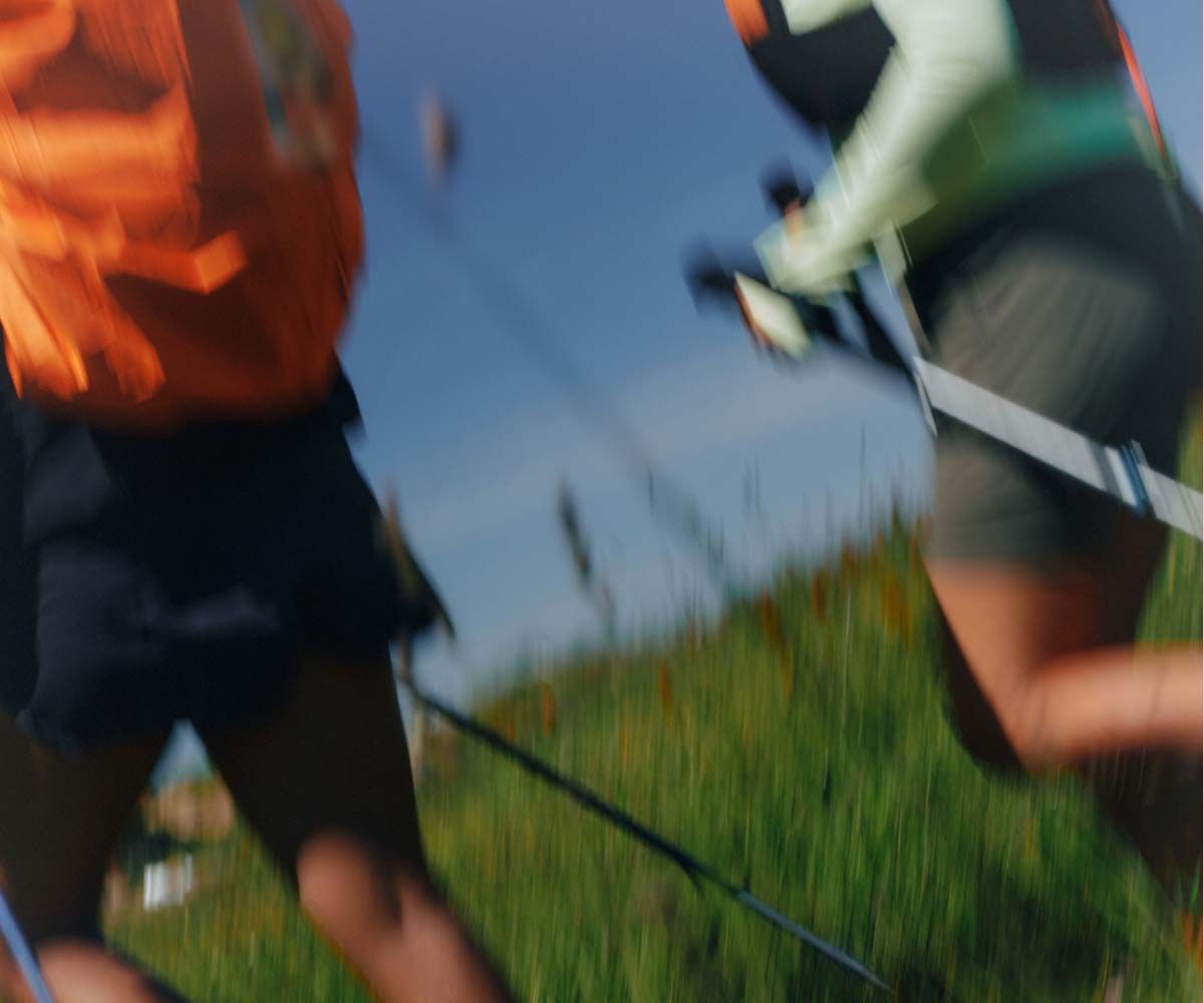 A woman and man running through a field with motion blur