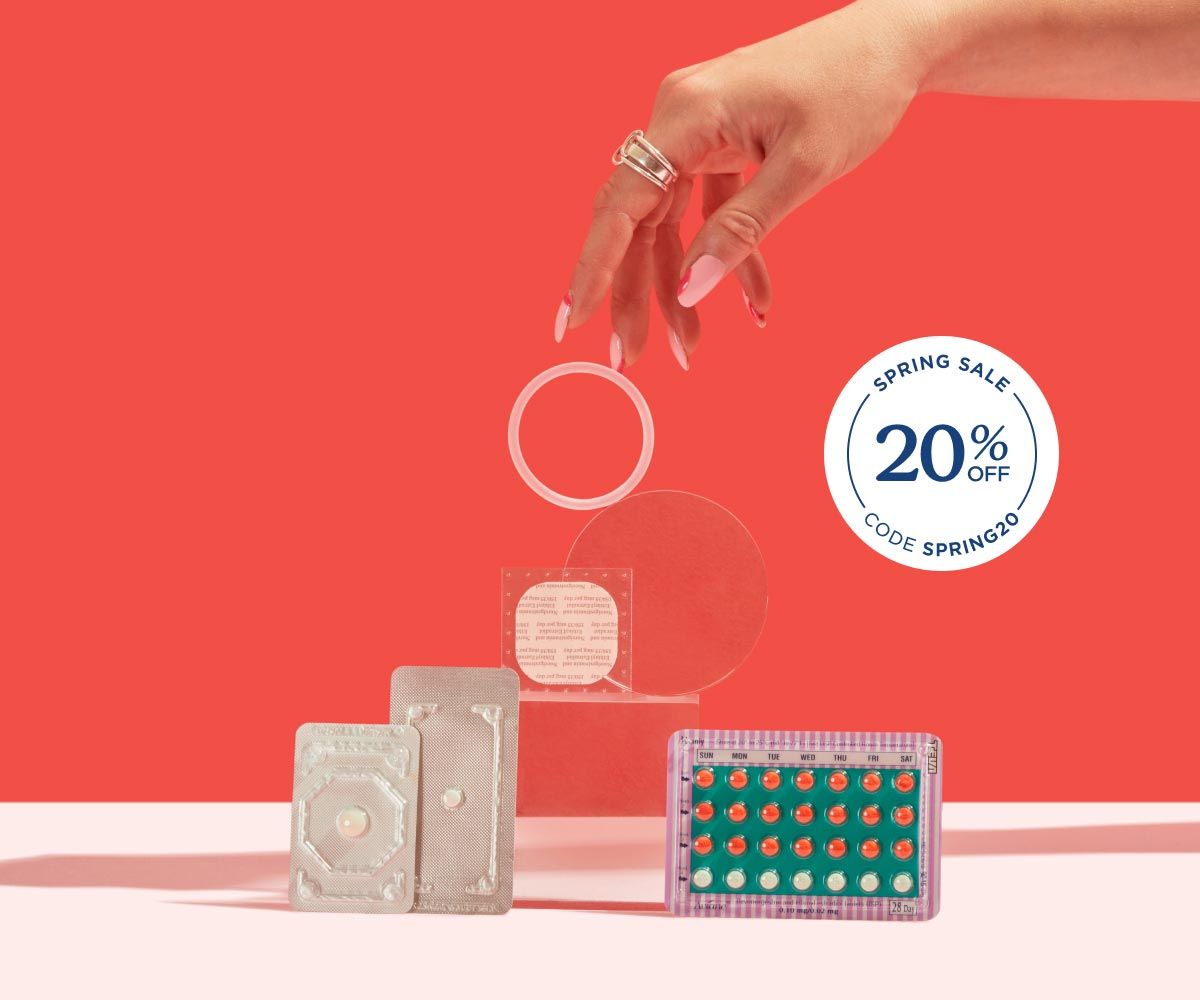 2 Emergency Contraception packets and a birth control packet, ring, and patch are balanced on a clear block on a pink surface with a red background