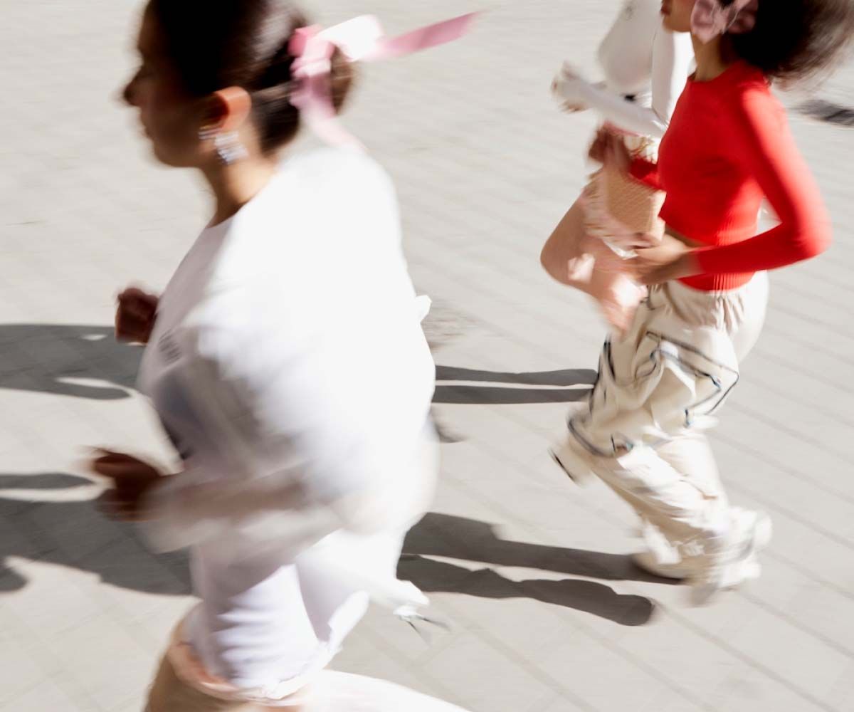 A group of women outdoors running with motion blur