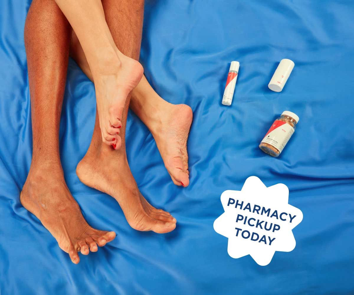 A couples feet intertwined on a blue comforter next to 3 Wisp products