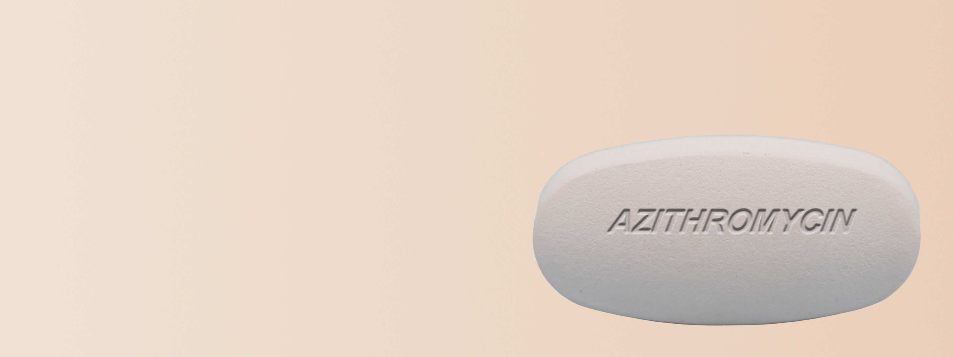 A white Azithromycin pill on a beige surface