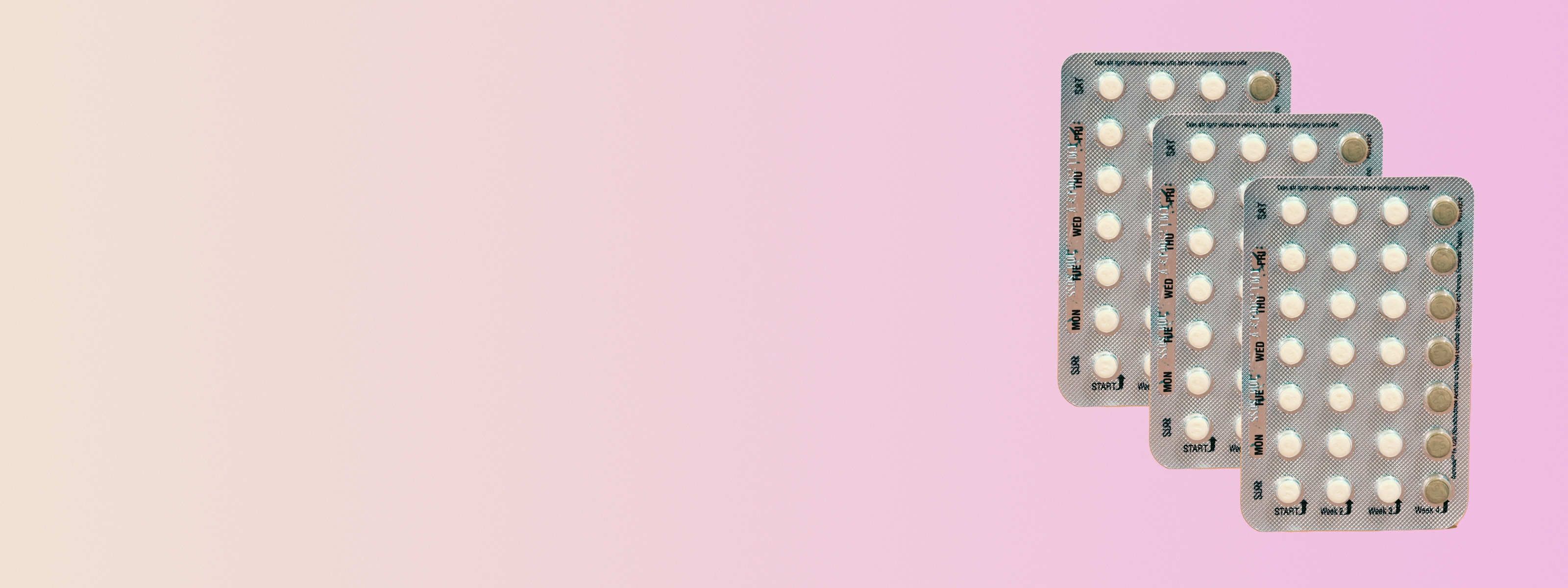 three packs of slynd birth control in front of a pink background