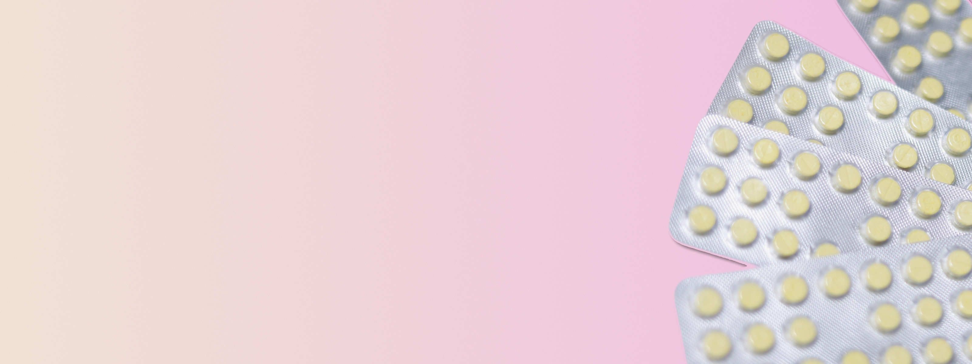 multiple sprintec birth control packs in front of a pink background