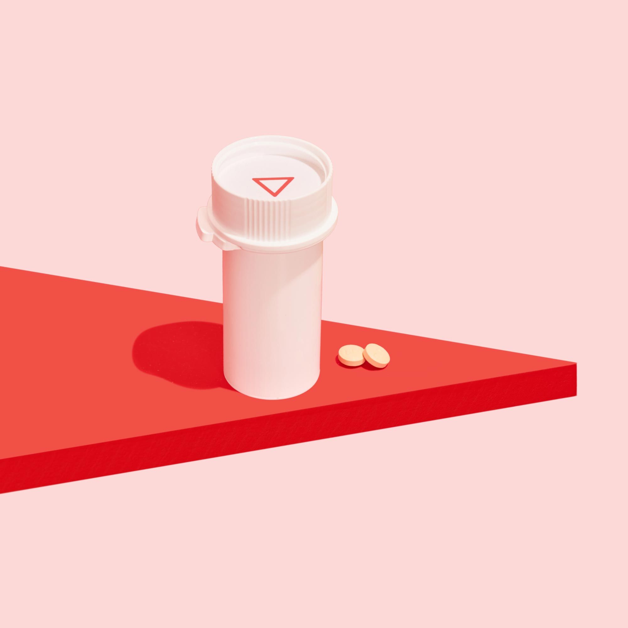 Two DoxyPEP pills and a pill vial on a red surface with a pink background
