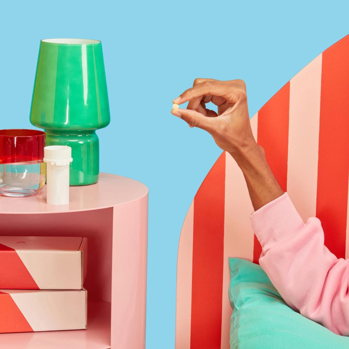 A man's hand holding DoxyPEP next to a nightstand