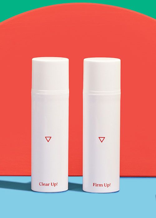 Wisp Clear Up Acne Cream and Firm Up Wrinkle Cream on a light blue surface with a red background