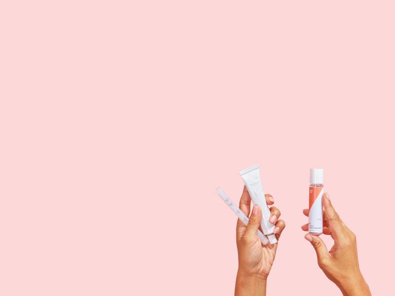hands holding Wisp Estradiol and Wisp lube on a pink background