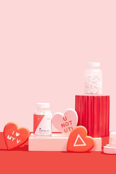 Woman's hand reaching for Wisp glass pill jars with colorful abstract shapes and red hearts on a pink and red backgroundX