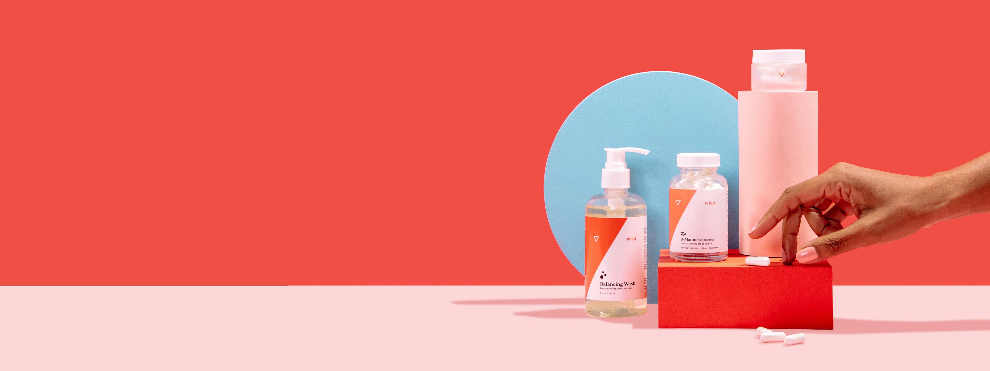Woman's hand reaches for Wisp Balancing Wash, D-Mannose, and Boric Acid on colorful geometric background