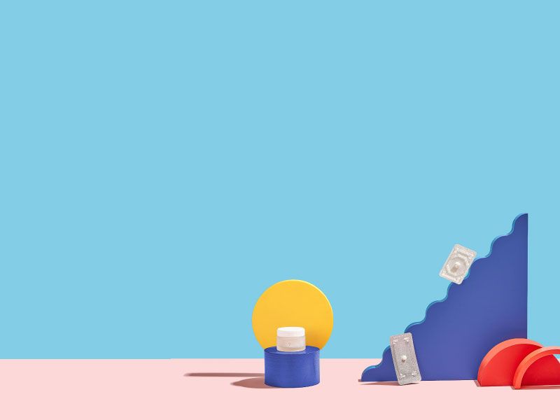 Wisp pill bottle, Plan B, and Ella packets with colorful abstract shapes on a pink and blue background