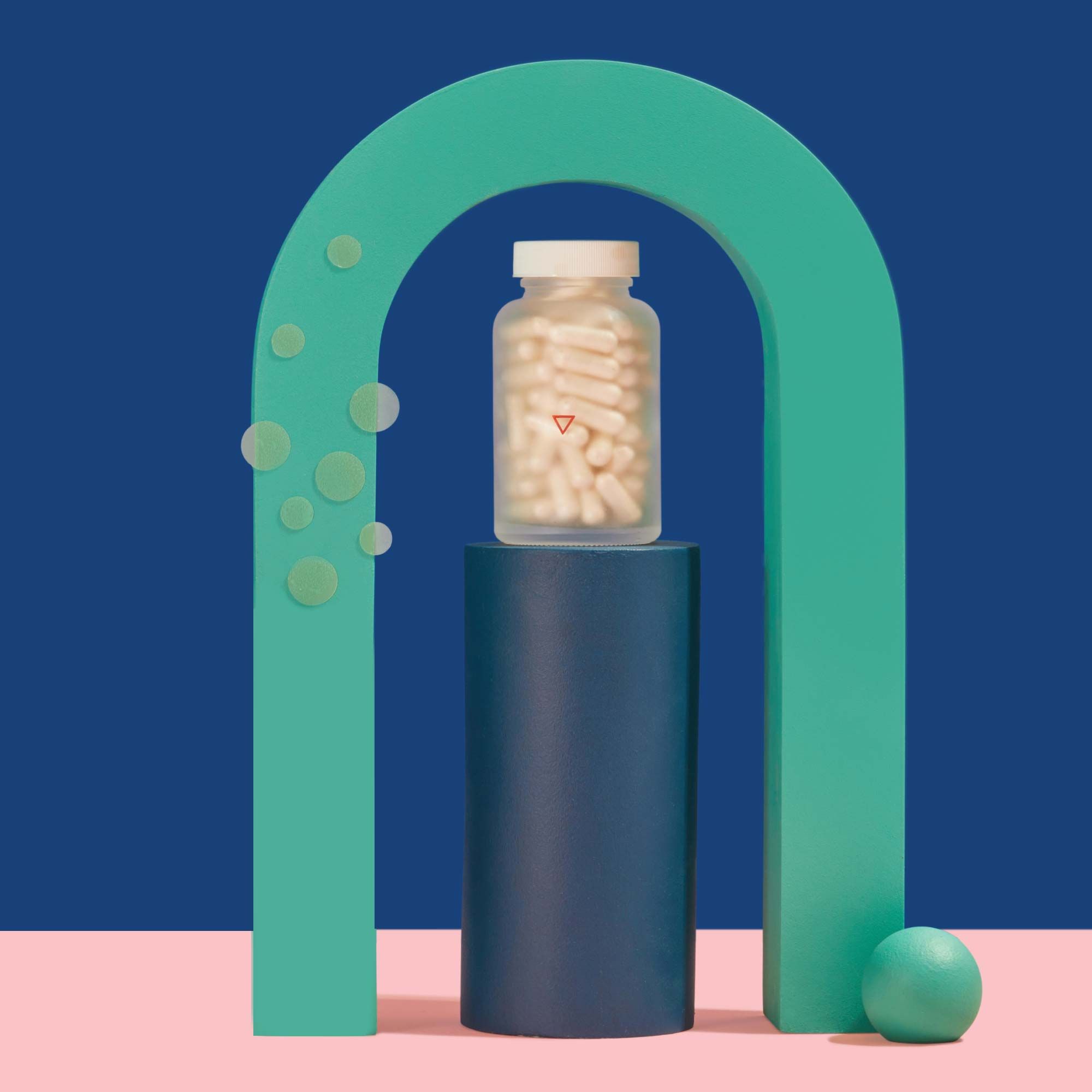 Wisp Cover Up Hydrocolloid Patches and a tall glass pill jar balanced on colorful abstract shapes on a pink surface with a blue background