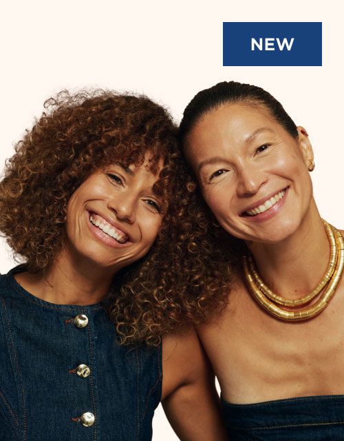 Two happy women of different ages in front of a cream background