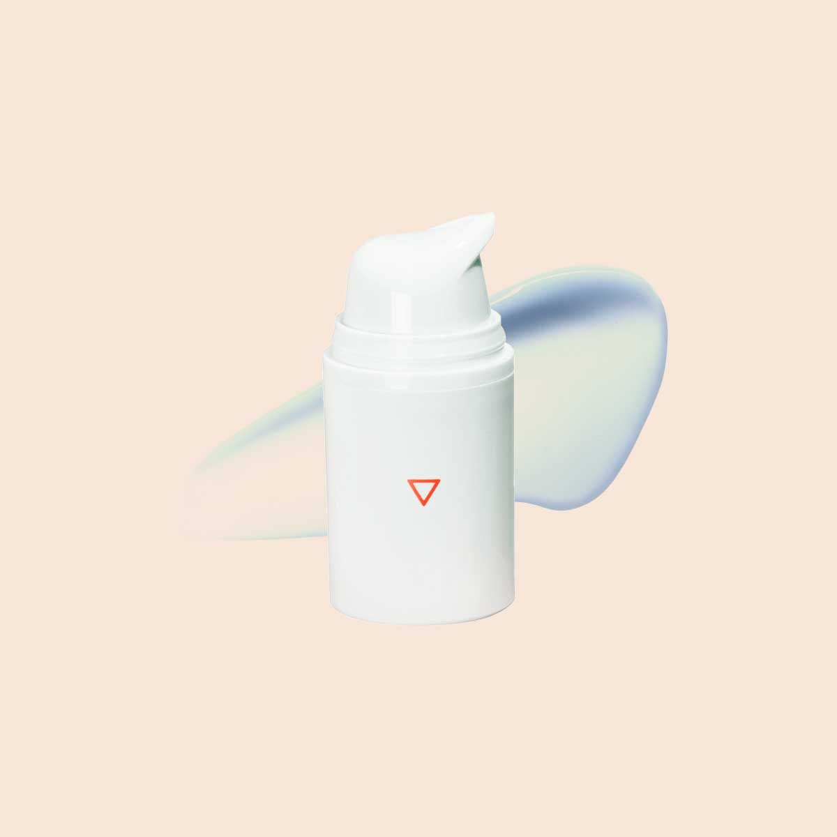 A Wisp pump bottle with a cream swatch on a beige surface