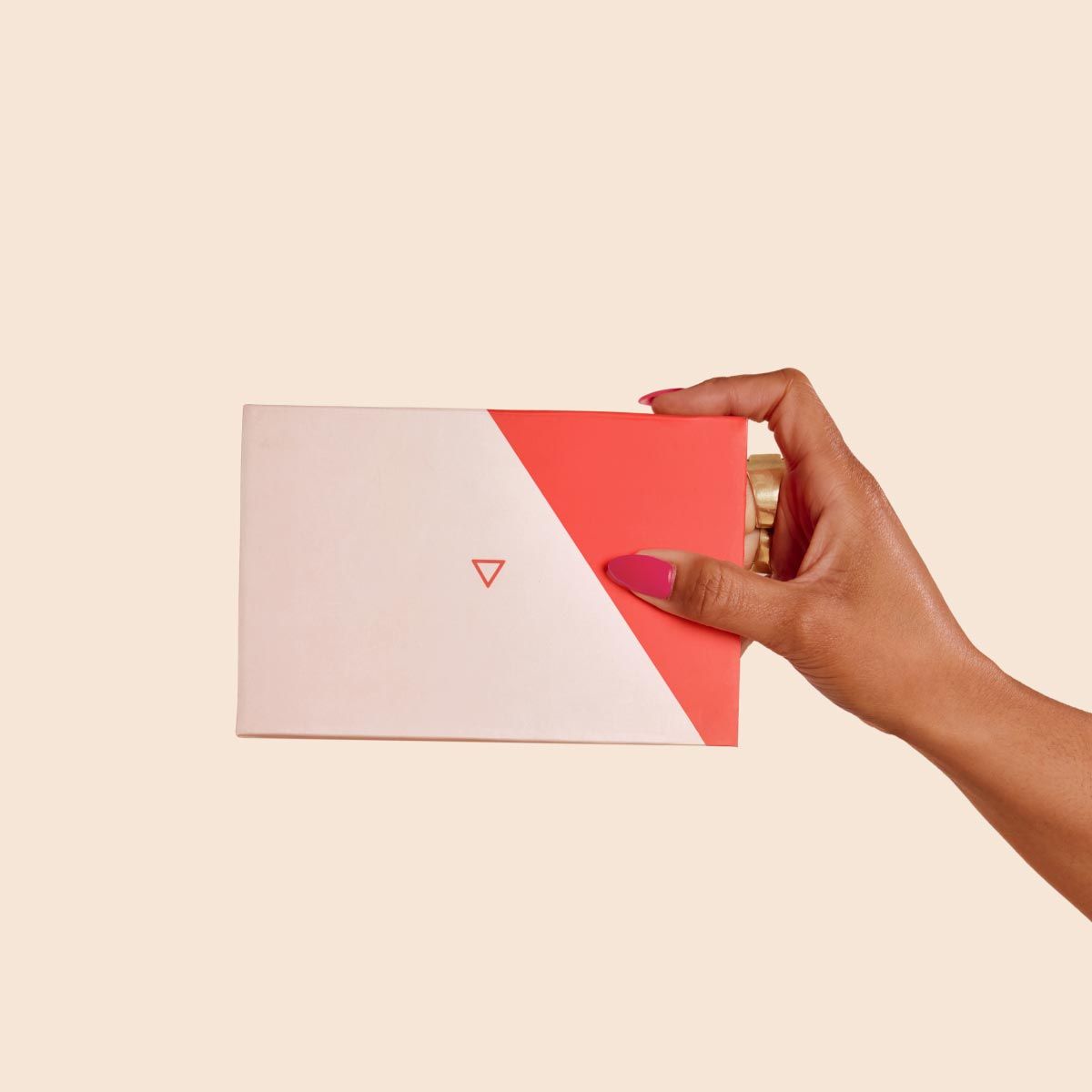 A person's hand holding a Wisp Diagnostics box with a cream background