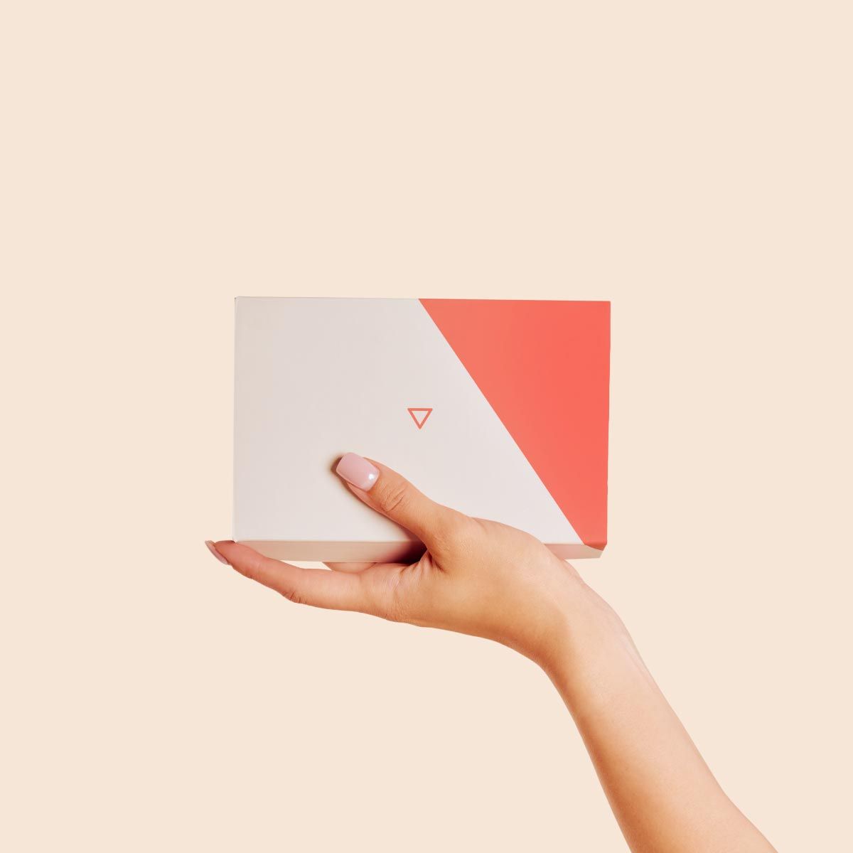 A person's hand holding a Wisp Diagnostics box with a cream background