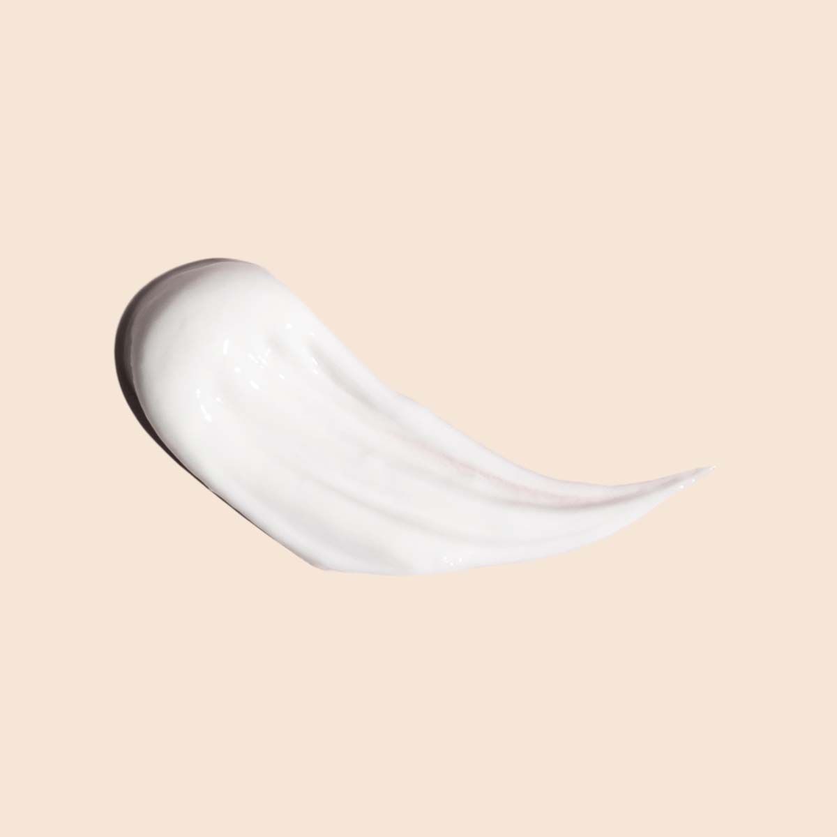 A cream swatch on a beige surface