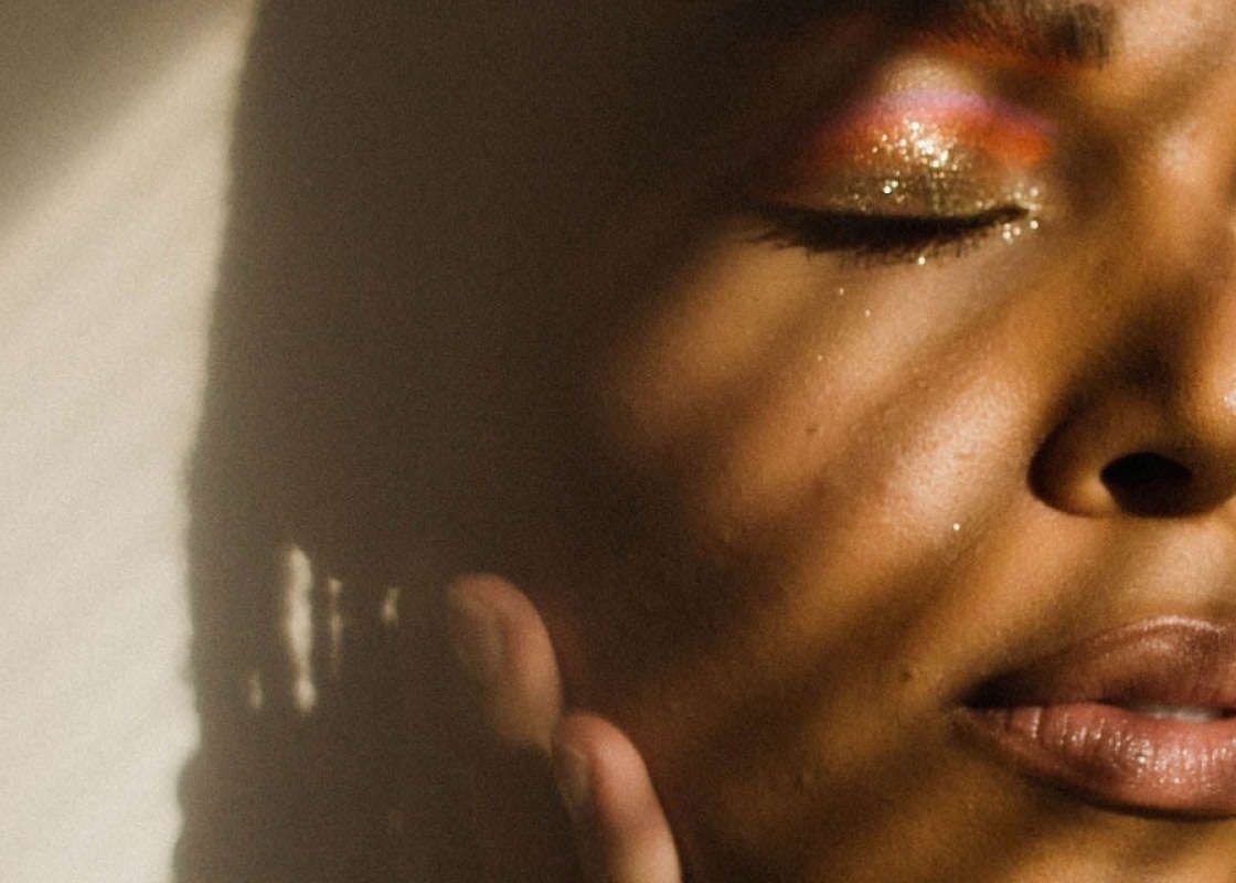 A close up moddy image of a woman with shadows across her face