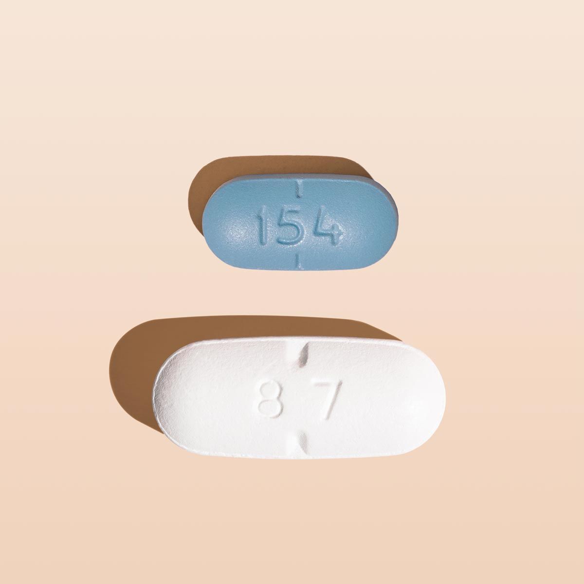 A white and blue pill on a cream surface