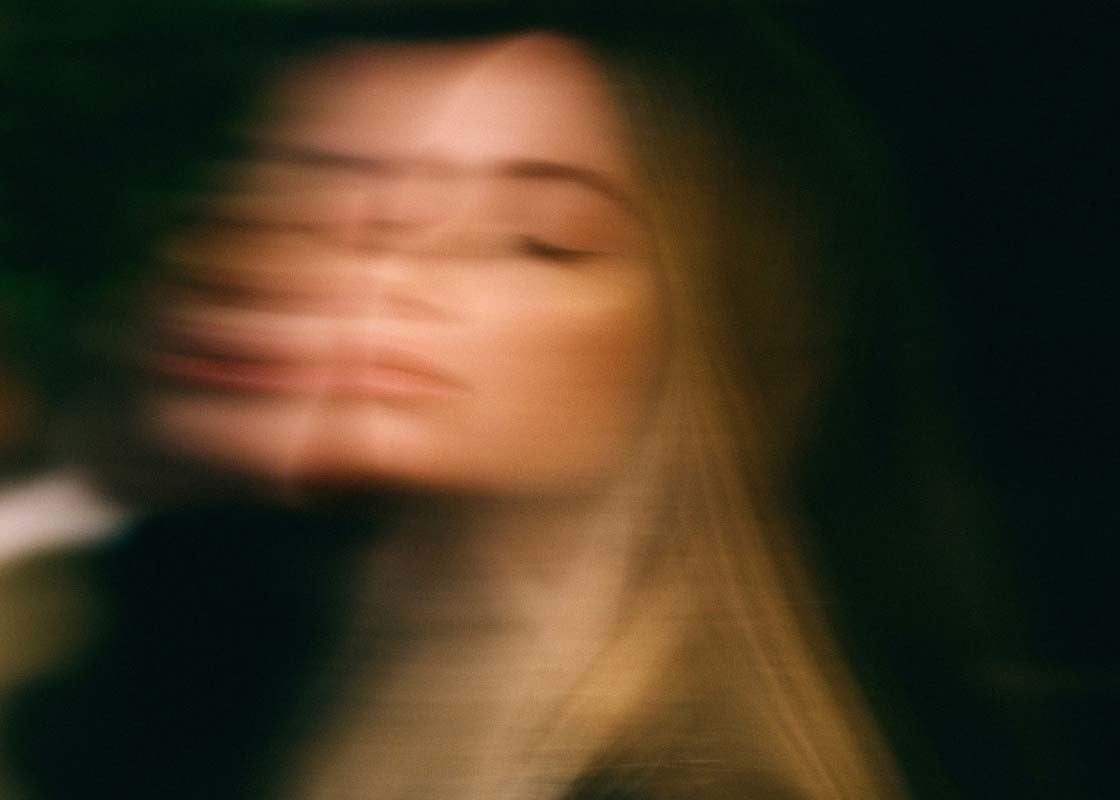 A moody motion blur image of a woman with blonde hair