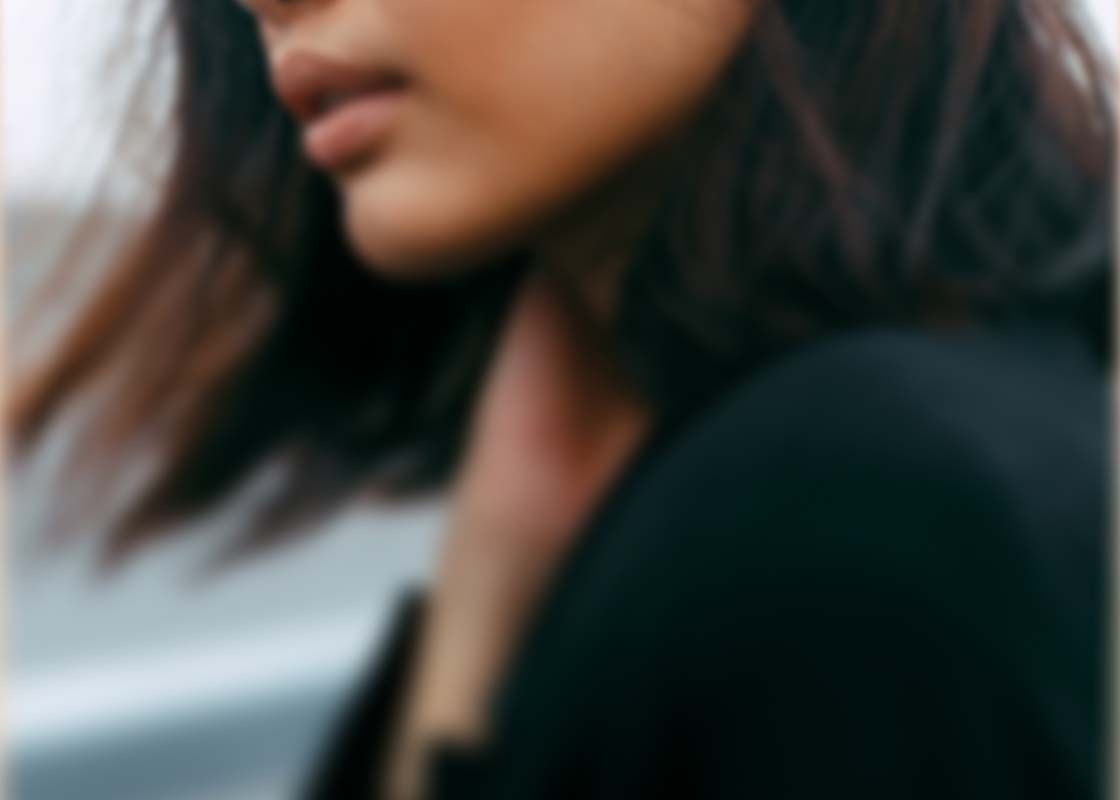 A close up of a woman with dark hair and clothing with motion blur