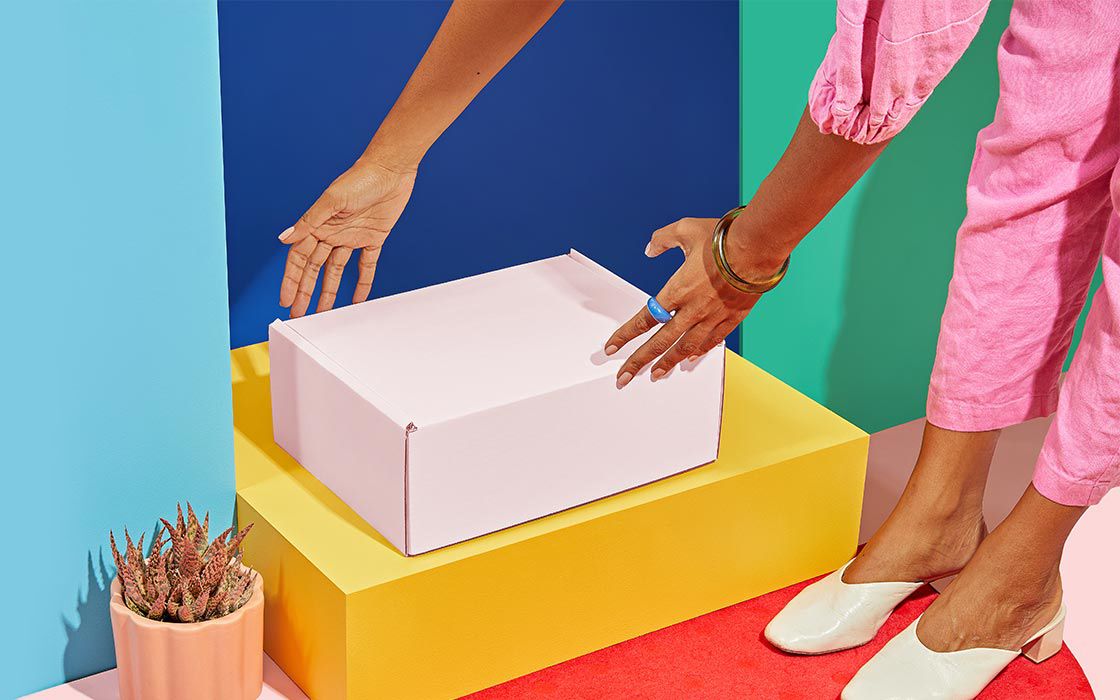 Woman reaches for discreet white box on doorstep