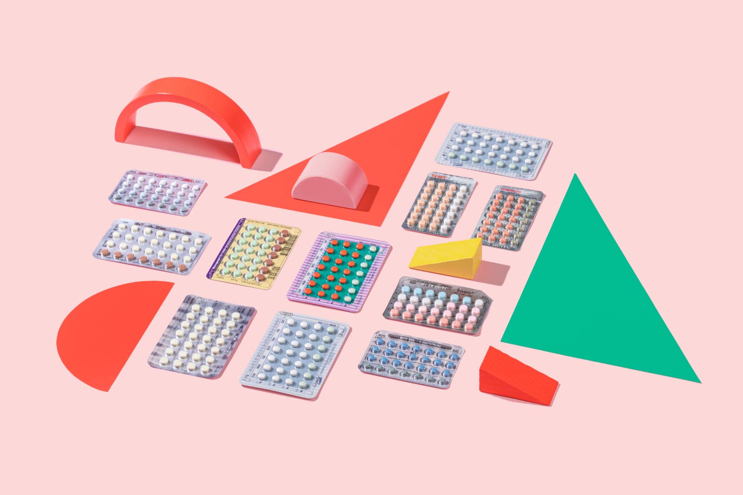 Several colorful birth control packets with colorful abstract shapes on a pink background