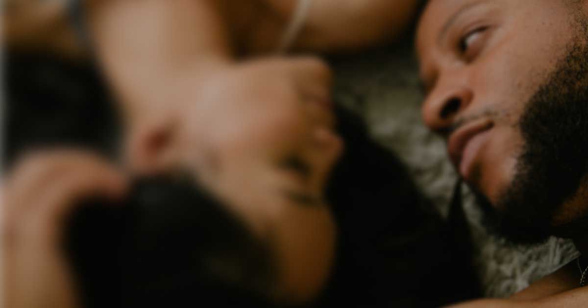 Close up of two people lying face to face in a relaxed moment