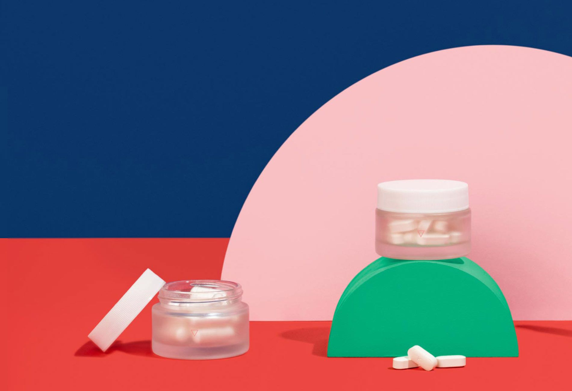 Wisp vaginal health medications in glass jars on a colorful geometric background