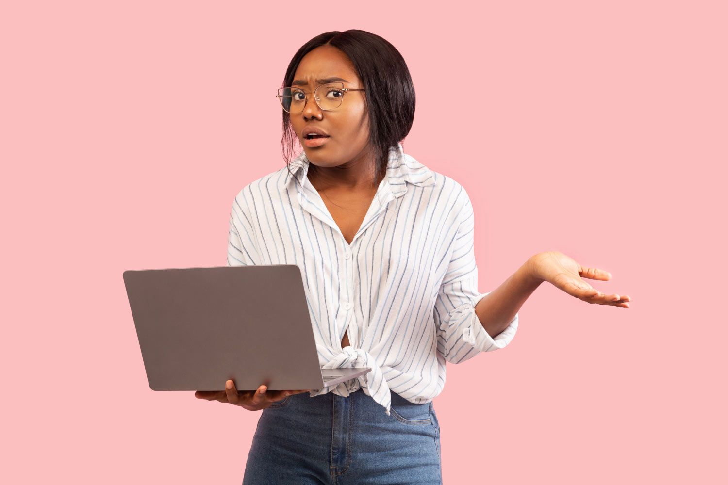 Female holding a laptop and looking confused with a pink background