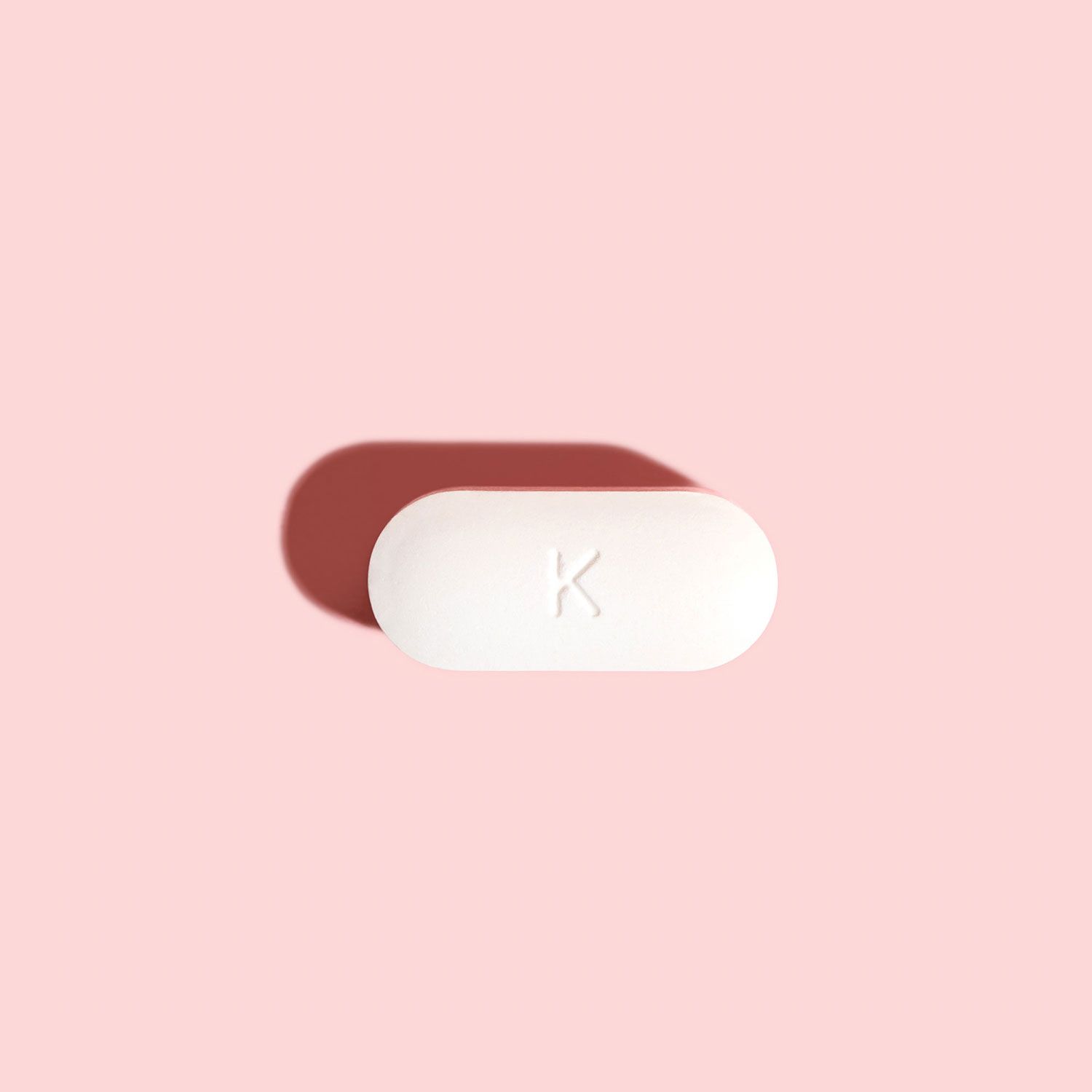 Single BV antibiotic tablet to treat bacterial vaginosis on a pink background