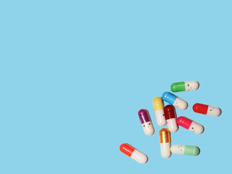 Colorful pills on a light blue surface