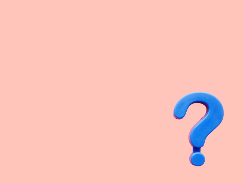 A purple question mark on a peach-colored background