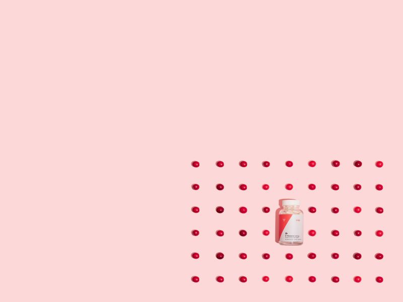 Wisp D-Mannose on a pink background surrounded by rows of cranberries