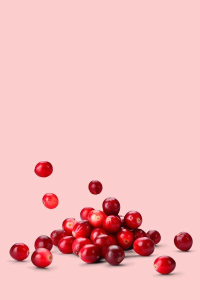 a pile of cranberries on a pink background