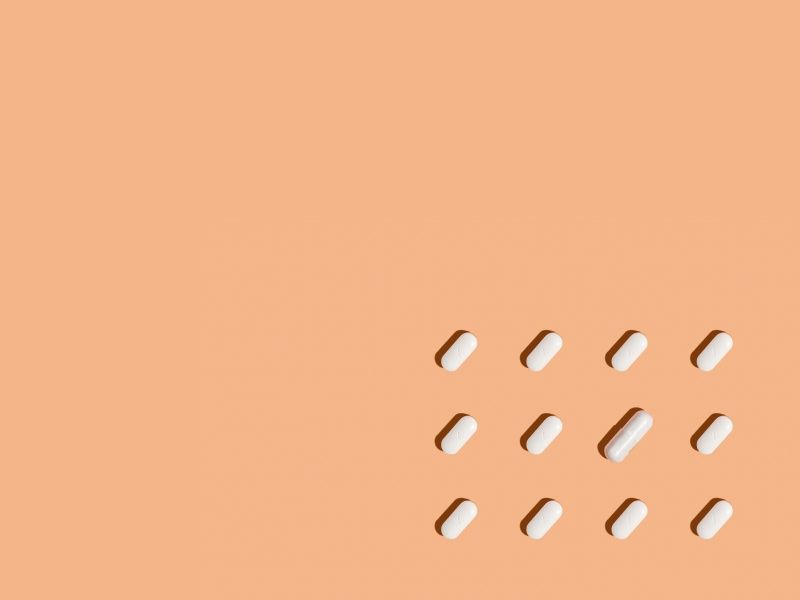 orange background with a mixture of white pills and capsules