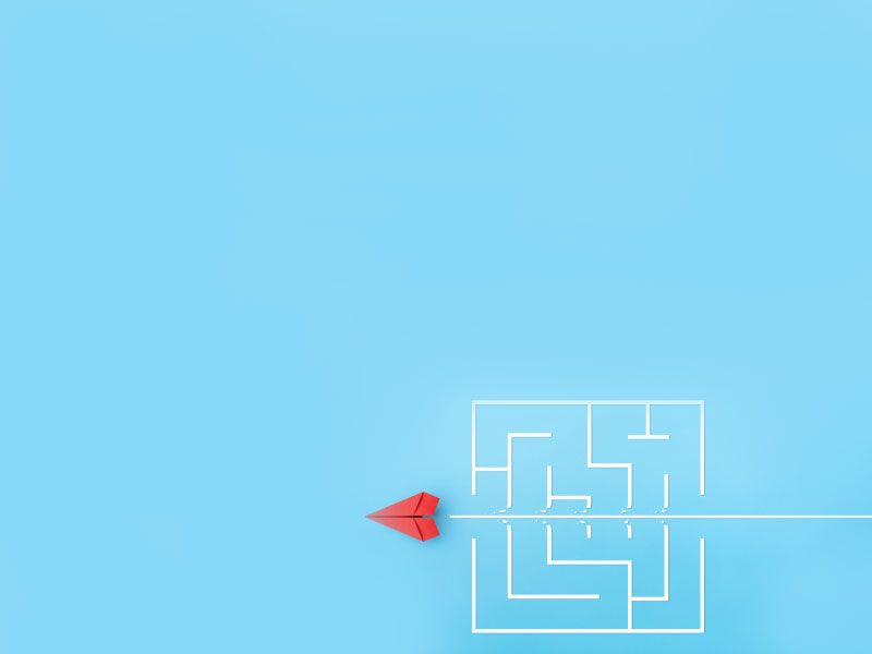 A red paper plan cutting through a white maze on a light blue background